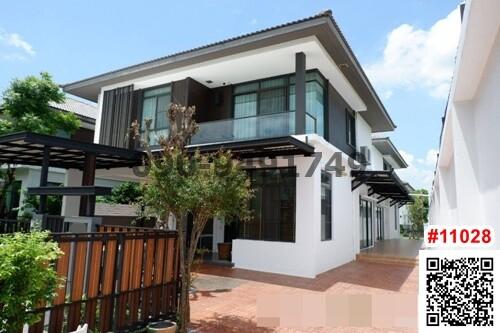 Modern two-story house with white exterior, large windows, and attached pergola