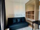 Modern bedroom with a black sofa and wooden bookshelf