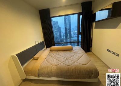 Modern bedroom with a view of the cityscape through large windows