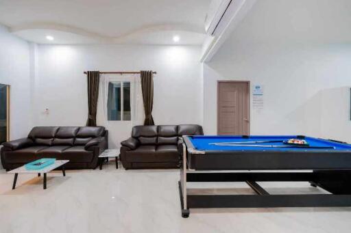 Spacious living room with pool table and modern furniture