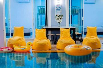 Indoor pool with yellow bean bag chairs and inflatable toys