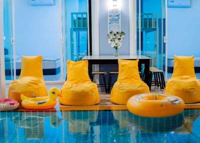 Indoor pool with yellow bean bag chairs and inflatable toys