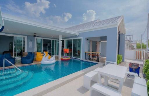 Spacious outdoor pool area with patio and lounge seats