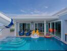 Bright outdoor pool area with waterslide and entertainment space