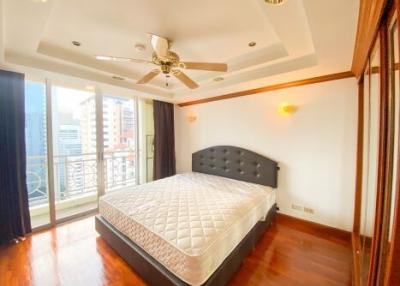 Spacious bedroom with hardwood floors and natural light