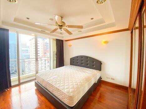 Spacious bedroom with hardwood floors and natural light