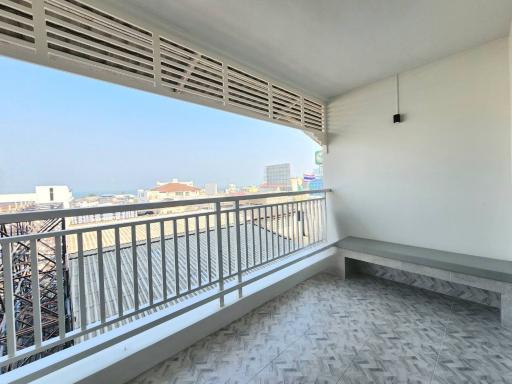 Spacious balcony with patterned floor and urban skyline view