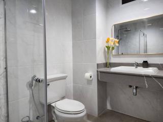 Modern bathroom with tiled walls, glass shower, and sleek sink