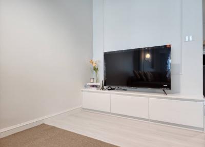 Minimalist living room with television and modern white cabinets