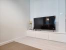 Minimalist living room with television and modern white cabinets