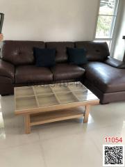 Spacious living room with large brown leather sofa and modern coffee table
