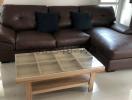 Spacious living room with large brown leather sofa and modern coffee table