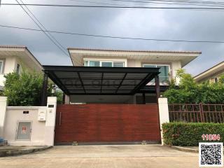 Modern house exterior with a red gate and carport