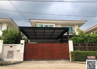 Modern house exterior with a red gate and carport