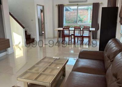 Spacious and well-lit living room with modern furnishings and staircase