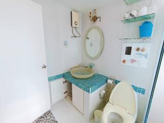 Compact bathroom with white and blue tile accents