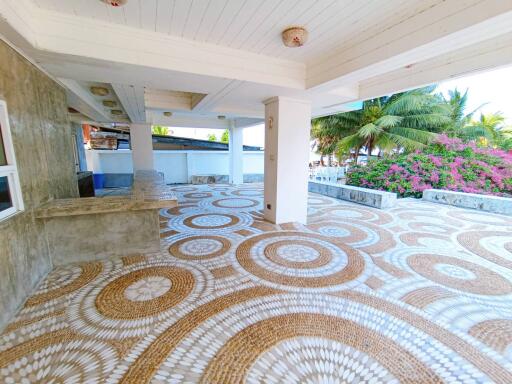 Spacious patio with decorative stone flooring and tropical landscaping