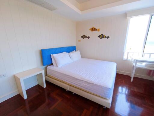 Bright bedroom with wooden floor and artistic wall decoration