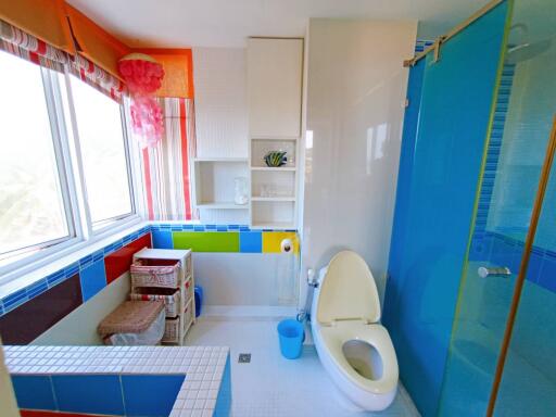 Bright and colorful bathroom with a shower cabin and a large window