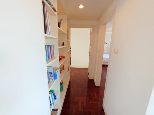 Bright corridor with bookshelf and herringbone parquet flooring