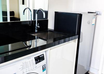 Modern kitchen interior with white appliances, black countertop, and QR code