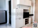Compact modern kitchen with built-in appliances and white cabinetry