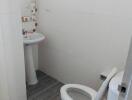 Compact bathroom with white tiles and essential fixtures