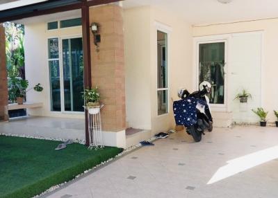 Covered patio area with tile flooring and a motorcycle parked
