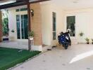 Covered patio area with tile flooring and a motorcycle parked