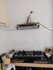 Compact kitchen space with gas stove and wall tiles