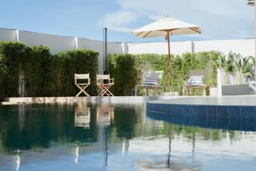 Modern backyard with pool, lounge chairs and umbrella