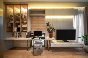 Modern home office with desk, shelves and television unit