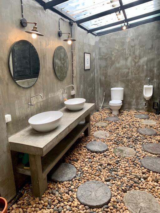 Modern rustic bathroom with natural stone floor and dual vessel sinks