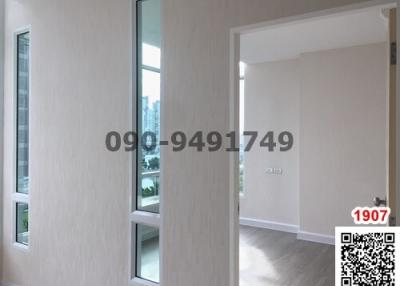 View through an open door into an empty, well-lit room with a window