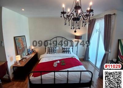 Cozy bedroom with elegant chandelier and queen-size bed