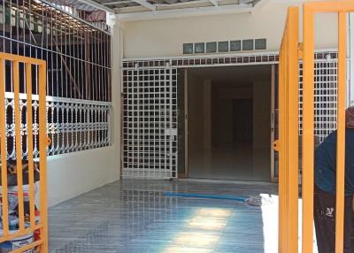 Bright and spacious tiled patio with protective grills and an open gateway leading to the interior of the house