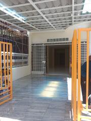 Bright and spacious tiled patio with protective grills and an open gateway leading to the interior of the house