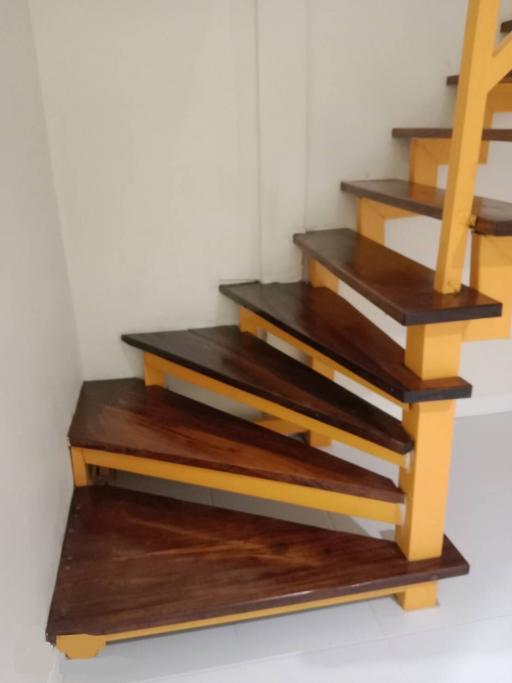 Wooden staircase with vibrant yellow railings