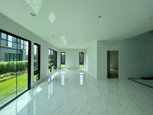 Spacious and luminous living room with large windows and marble flooring