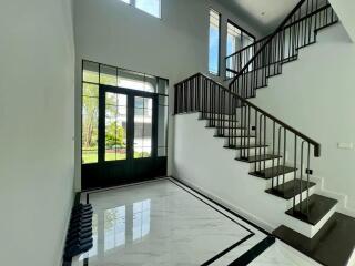 Bright and modern entryway with staircase and large window