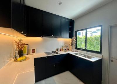 Modern kitchen with black cabinetry and white countertops