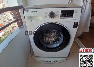 Samsung washing machine in a small utility area with balcony view