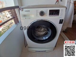 Samsung washing machine in a small utility area with balcony view