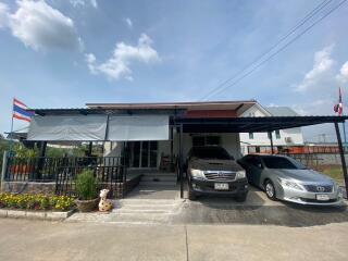 Suburban single-family house with a carport and two parked cars