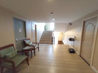 Spacious hallway with wooden floors, staircase, and seating area