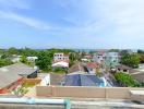Panoramic view from the rooftop overlooking a residential area with sea in the background