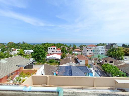 Panoramic view from the rooftop overlooking a residential area with sea in the background