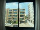 Window view of urban residential buildings and parking