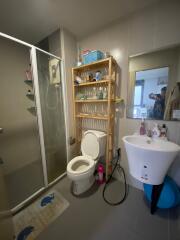 Compact bathroom with shower stall, toilet, and sink