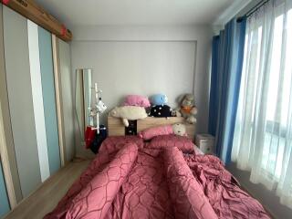 Cozy bedroom with a neatly made bed and plush toys